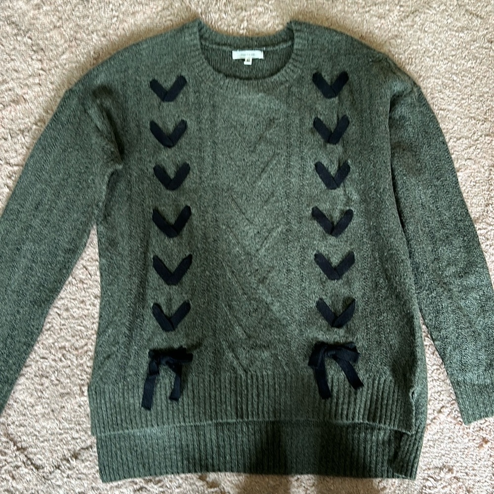 Green sweater with black bows.